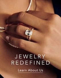 Model wearing gold diamond engagement ring, wedding band, and fine jewelry.