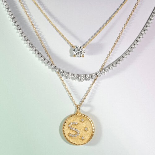 Assortment of personalized, tennis, and solitaire necklaces.