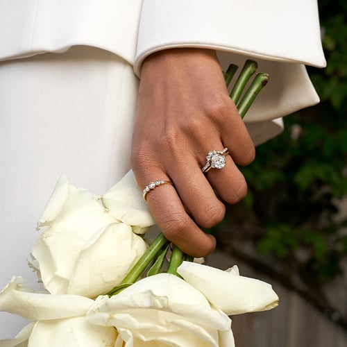 bride with diamond rings holding wedding bouquet