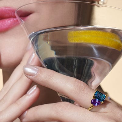 woman holds cocktail wearing toi et moi ring
