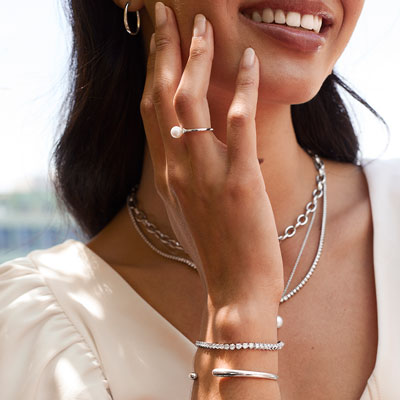 model wears white metal jewelry