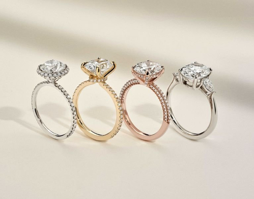 Assortment of diamond engagement rings in different metal types.