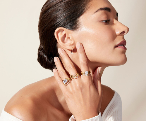 Model wearing an assortment of yellow gold rings