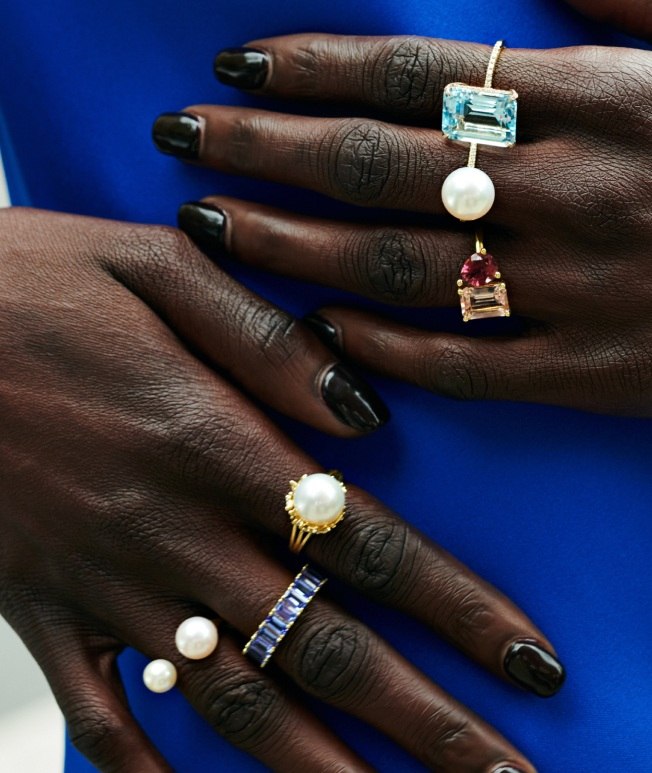 Model wearing assortment of cocktail rings and fashion rings.