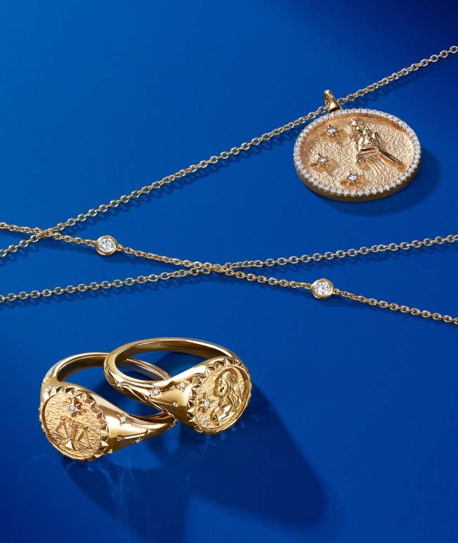Assortment of a gold medallion necklace and medallion rings.