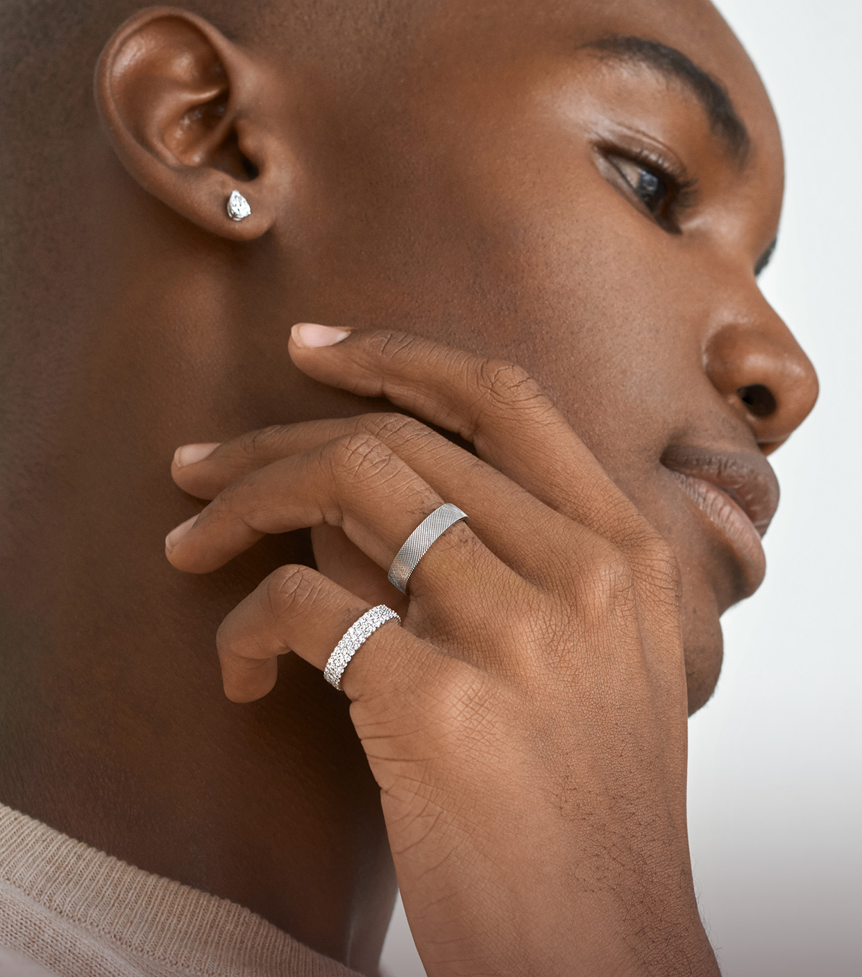 Model wearing white gold and diamond wedding bands, and diamond stud earrings.