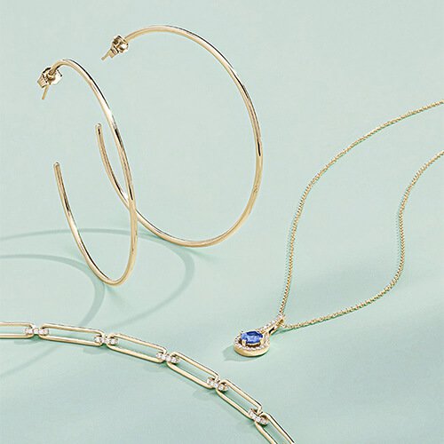gold hoops, chain necklace, and gemstone necklace fine jewelry
