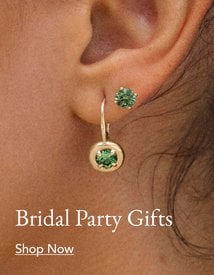 Person wearing gold emerald earrings, perfect for bridal party gifting.