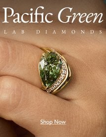 Model wearing an engagement ring set with a pacific green lab diamond.