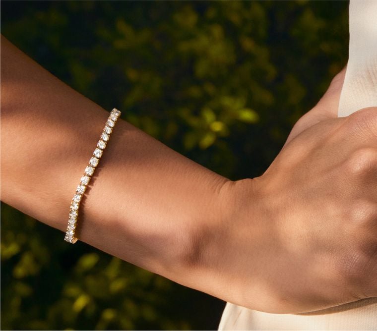 Model wearing a diamond tennis bracelet.