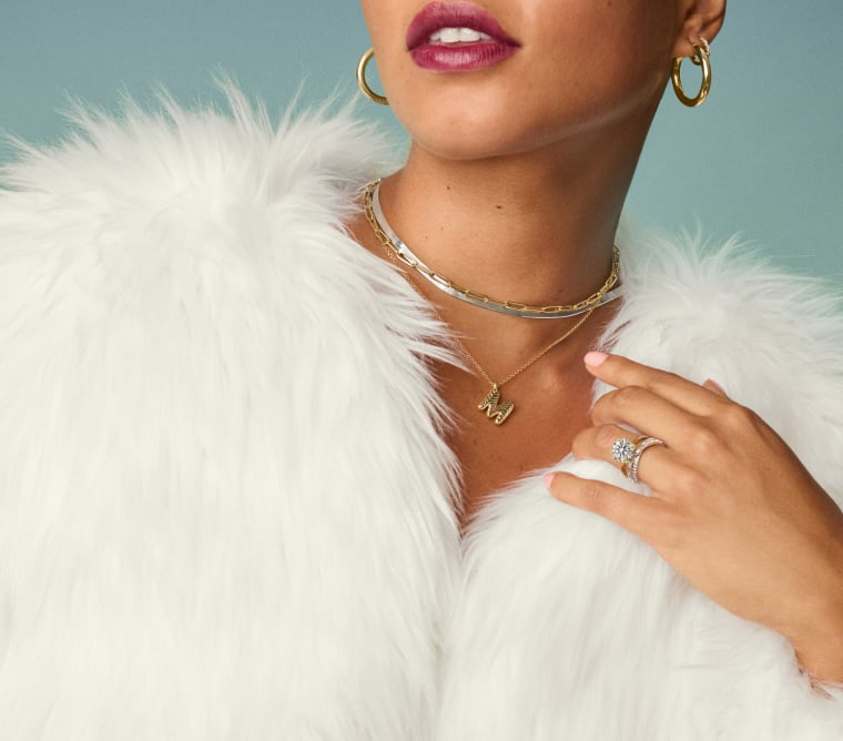 Model wearing an assortment of diamond fine jewelry