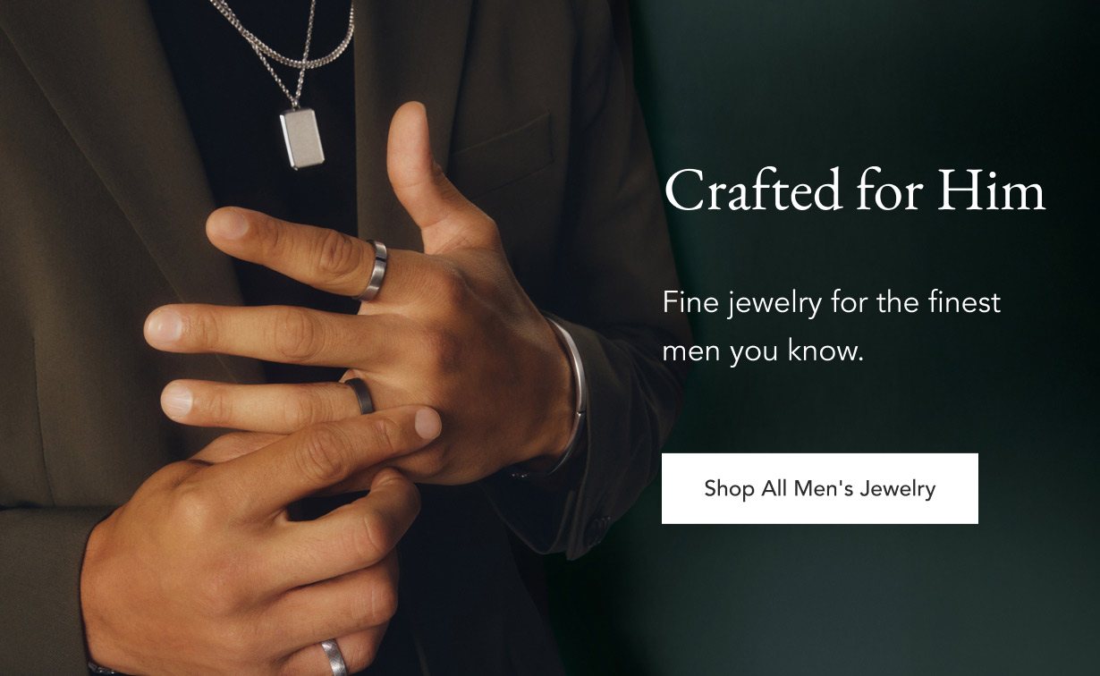 Model wearing variety of men’s wedding bands and chain necklaces.