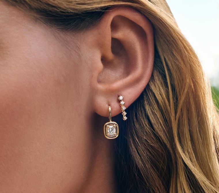 Model wearing yellow gold diamond earrings.