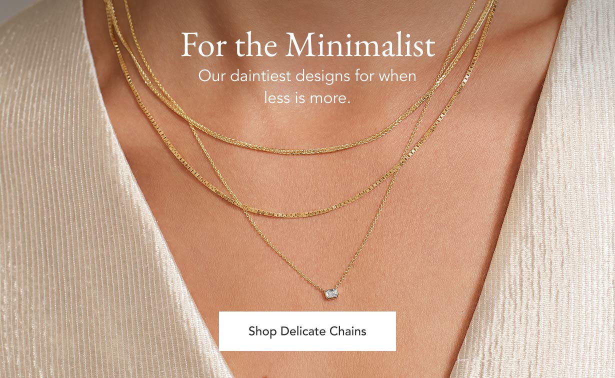 Model wearing delicate chain necklaces.