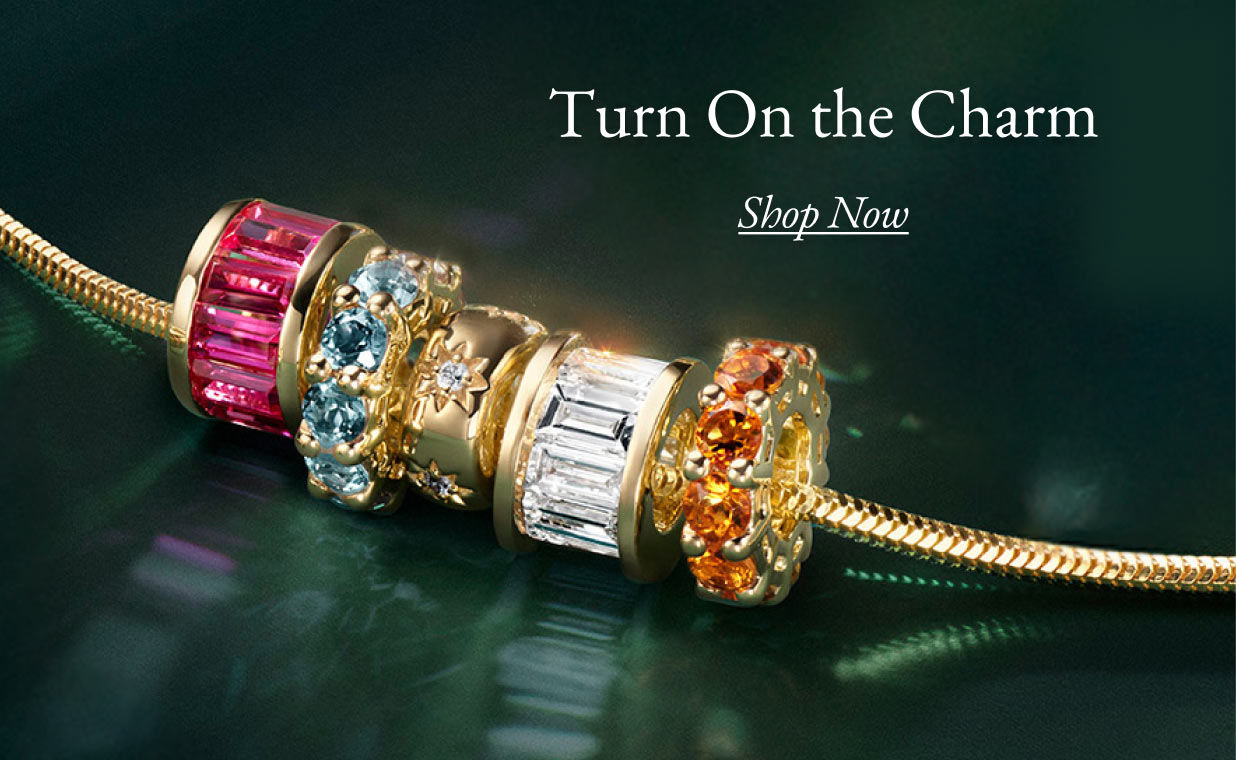 A gold chain with an assortment of diamond and gemstone charms.