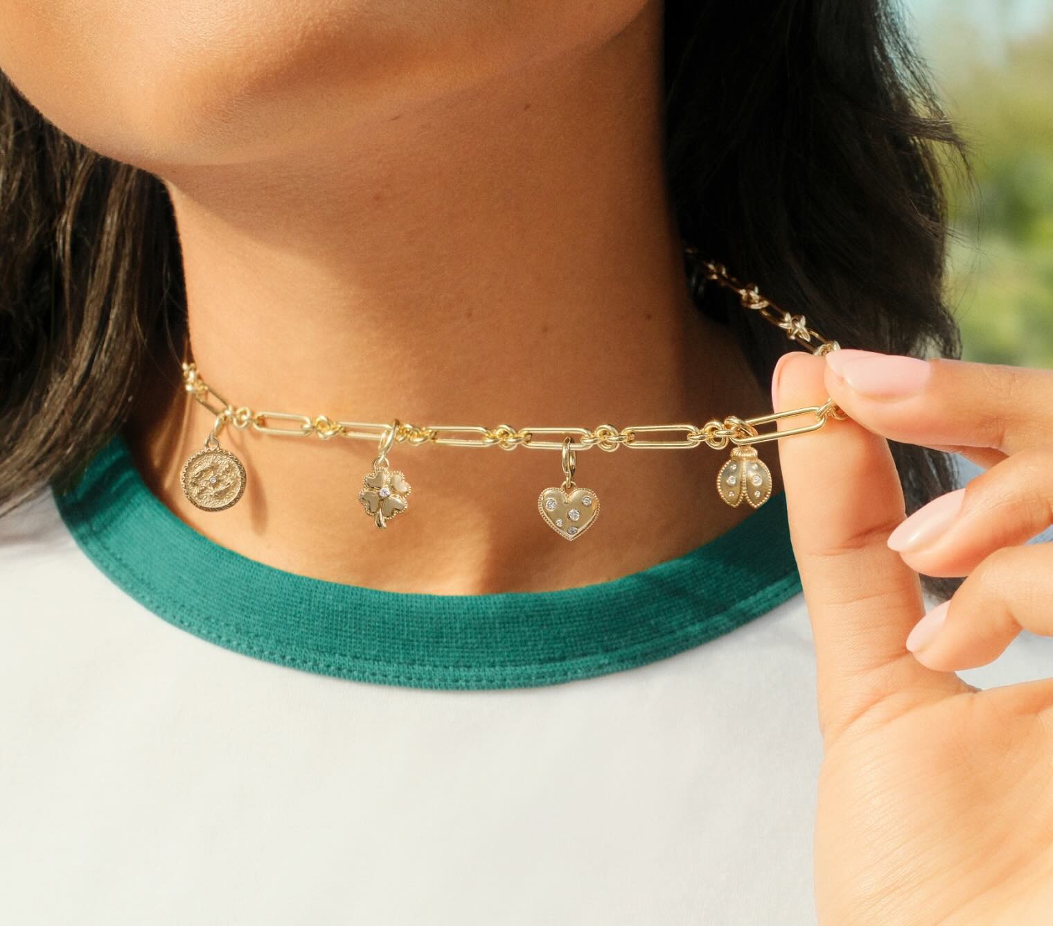 Model wearing a gold charm necklace.