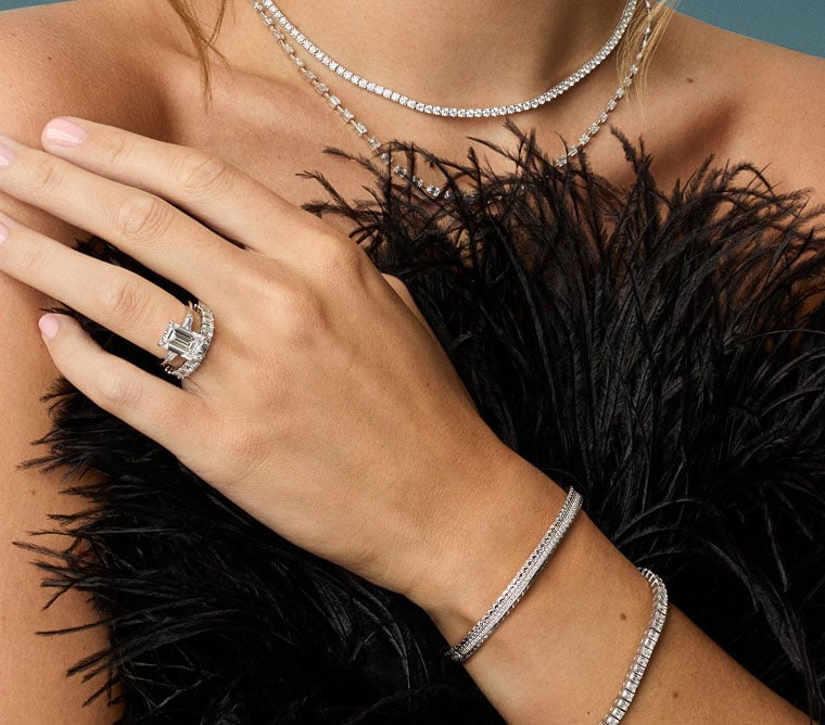 Model wearing assortment of diamond fine jewelry and diamond engagement ring.