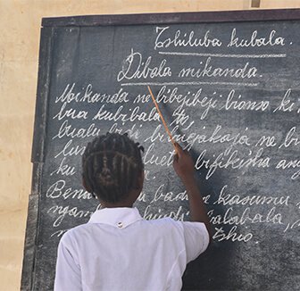 Student writing on chalkboard