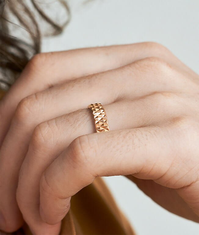 Lustrous rose gold textured ring on hand