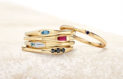 Stack of gold fashion rings set with diamonds and gemstones